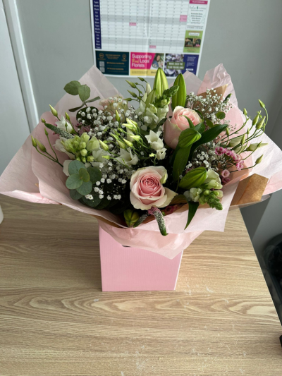 Blushing Lily Rose - A graceful and romantic arrangement presented in a soft pink box. Pink Roses and White lillies accented with fresh greenery and seasonal blooms, this design offers a perfect balance of softness and structure. Ideal for special occasions, heartfelt gifts, or adding a touch of charm and sophistication to any setting.